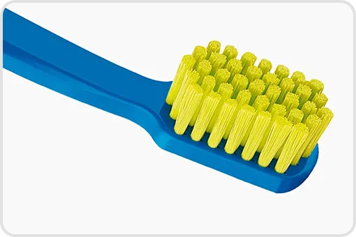 Close-up view of Curaprox 1560 toothbrush with blue handle and yellow bristles