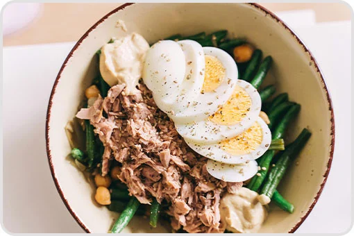 Ensalada con ejotes, atún desmenuzado, hummus y huevo cocido en rodajas, receta nutritiva y suave tras una extracción dental en Coyoacán, CDMX