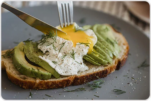 Tostada crujiente con rebanadas de aguacate, huevo pochado y eneldo, no recomendada justo después de una extracción dental en Coyoacán, CDMX